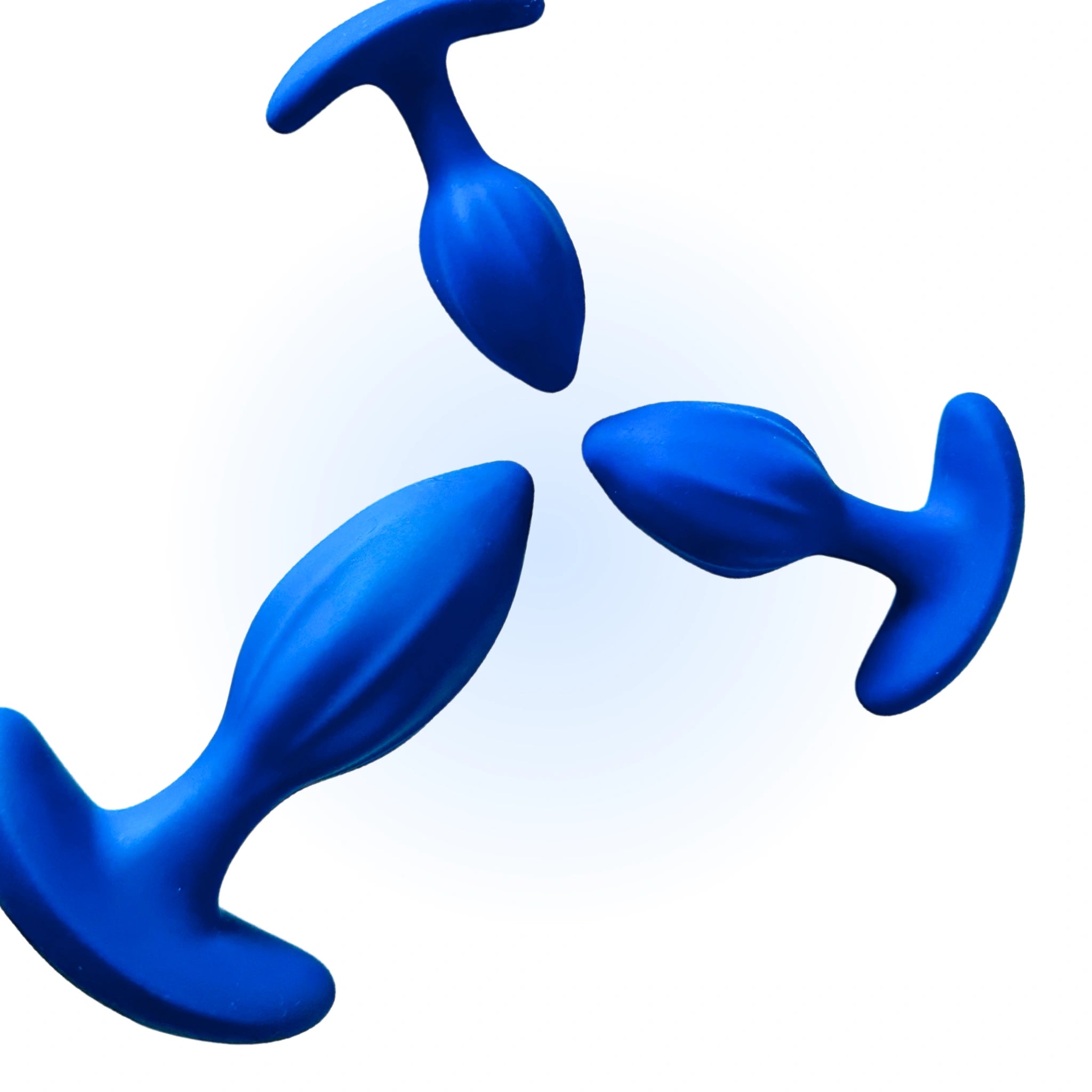 Three blue silicone anal plugs of varying sizes are arranged against a light blue background, showcasing their smooth, tapered design.