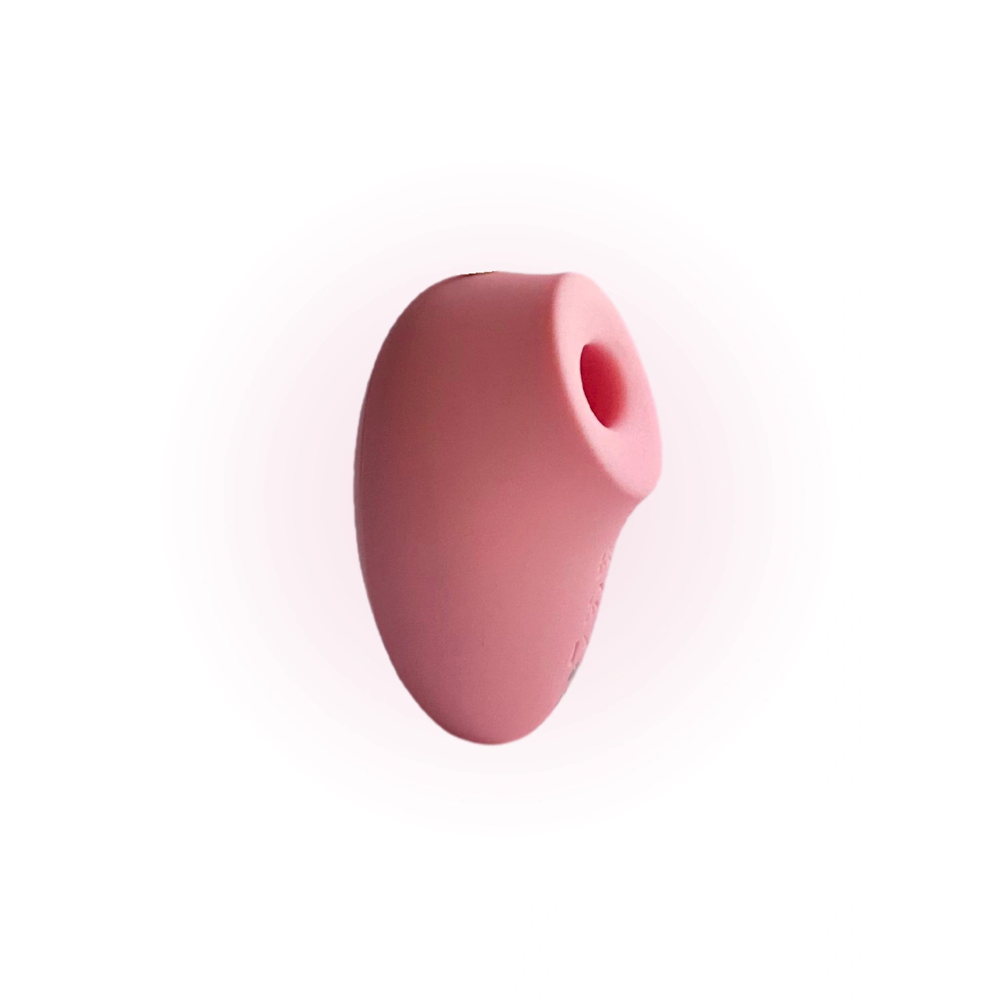 A close-up image of a pink, oval-shaped silicone stimulator with a rounded opening, shown against a white background.