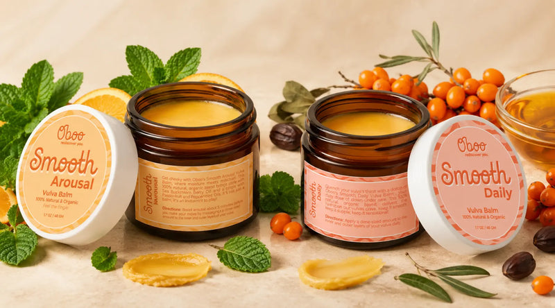 Oboo Smooth Arousal and Smooth Daily Vulva Balm jars displayed with mint, orange slices, sea buckthorn berries, and balm swatches.