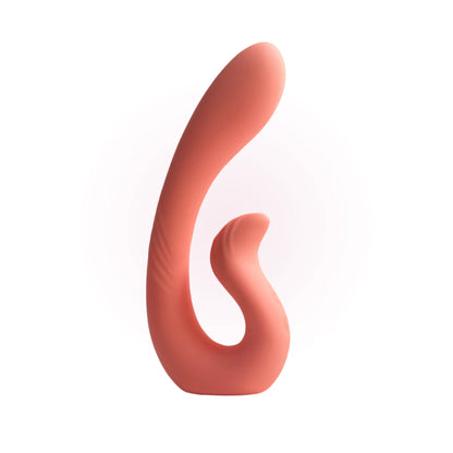 A coral-colored dual-stimulation massager with a curved, ergonomic design is displayed upright against a soft pink gradient background.