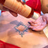 A person in red lingerie applies Loob Arousal lubricant onto fingers, showing targeted use on lower abdomen with visible tattoo.