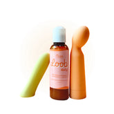 A bottle of Oboo Loob Daily lubricant is placed between two colorful massagers on a soft peach background.