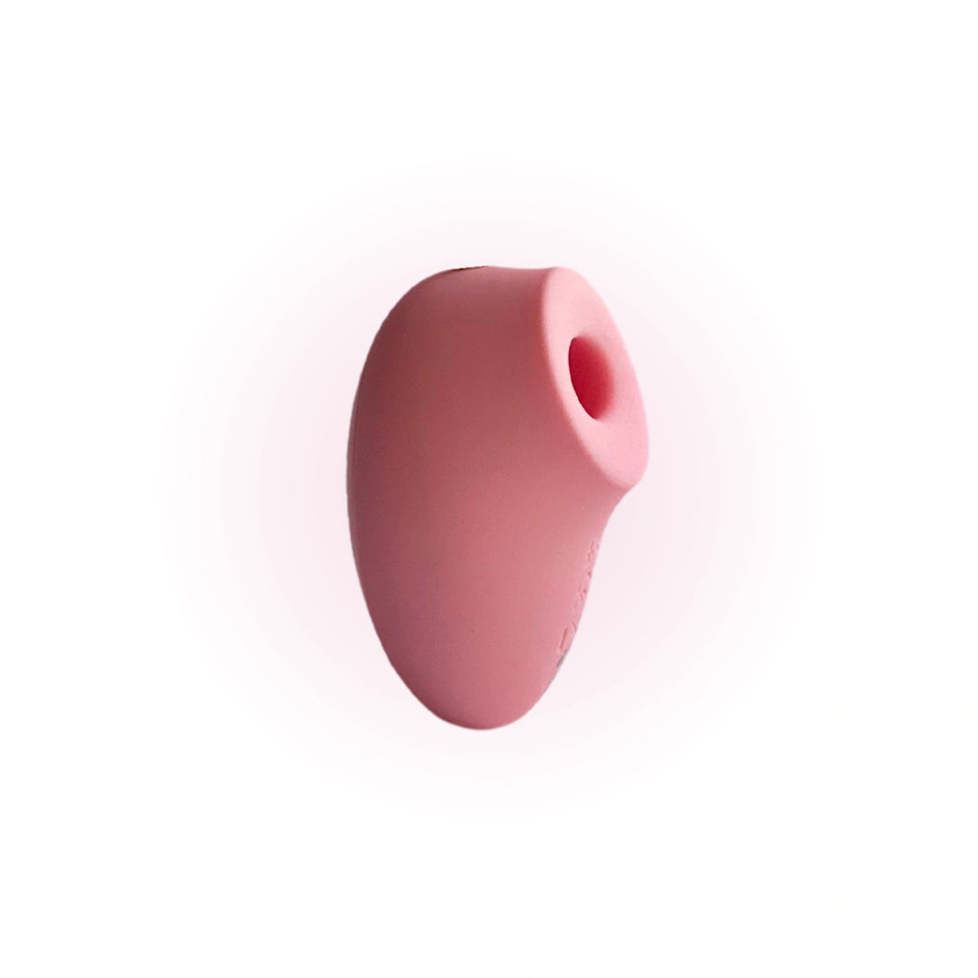 A close-up image of a pink, oval-shaped silicone stimulator with a rounded opening, shown against a white background.