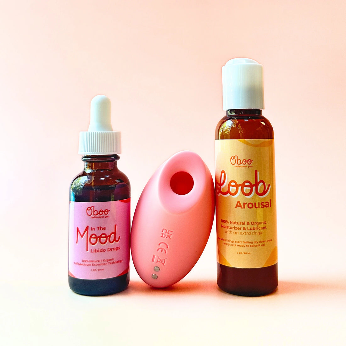 Three Oboo products – Libido Drops, Arousal Loob, and a pink stimulator – displayed against a soft pink background.